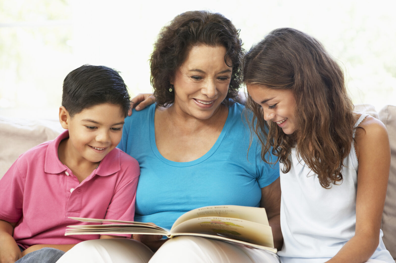 Grandmother Reading With Grandchildren At Home Together